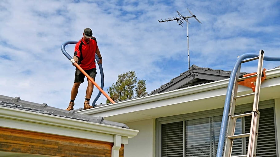Man cleaning roof and gutter efficiently
